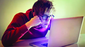 Young man reading on a laptop